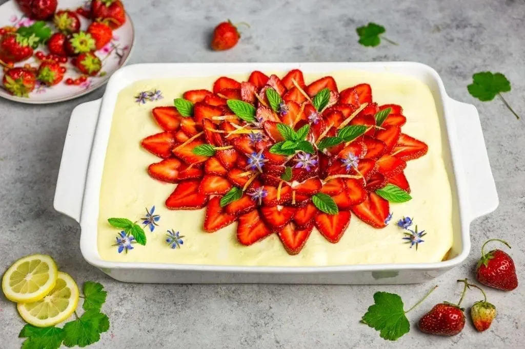 A dish of tiramisu covered in strawberry slices