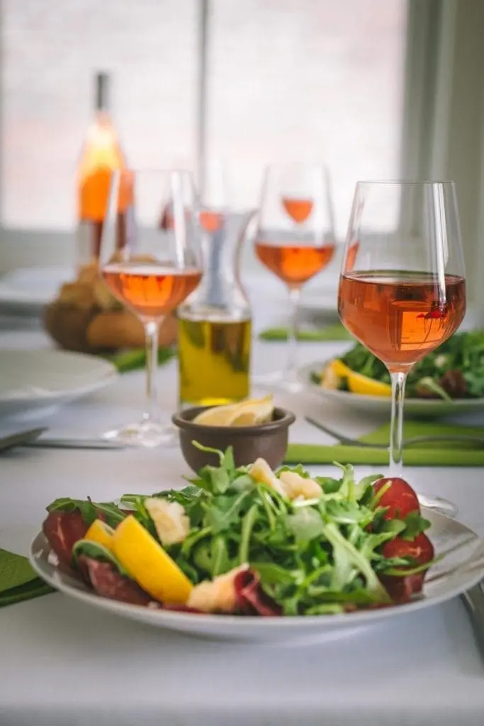 Wine glasses and dinner plates arranged on a clothed table