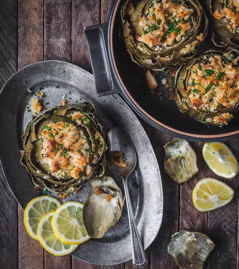 Artichokes stuffed with crab dip on a platter