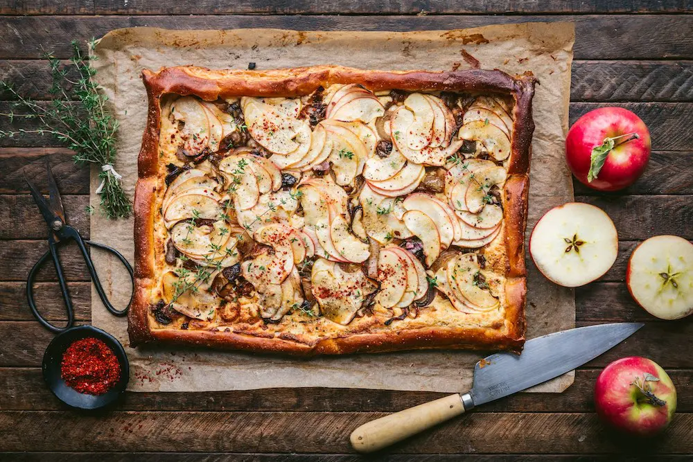 A baked apple tart with sliced apples around it