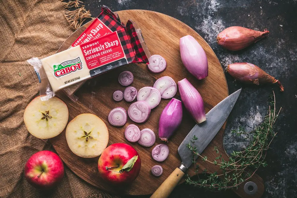 Sliced shallots, apples and a block of cheese