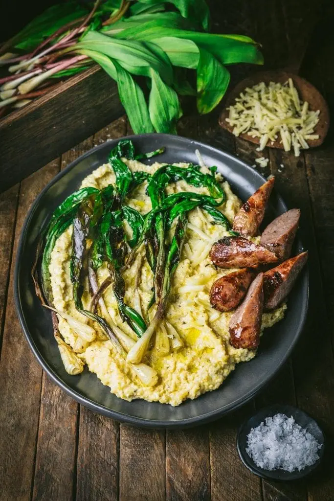 A bowl of polenta, sausages and sautéed ramps