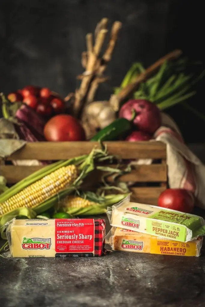 Blocks of cheese in front of a vegetable basket