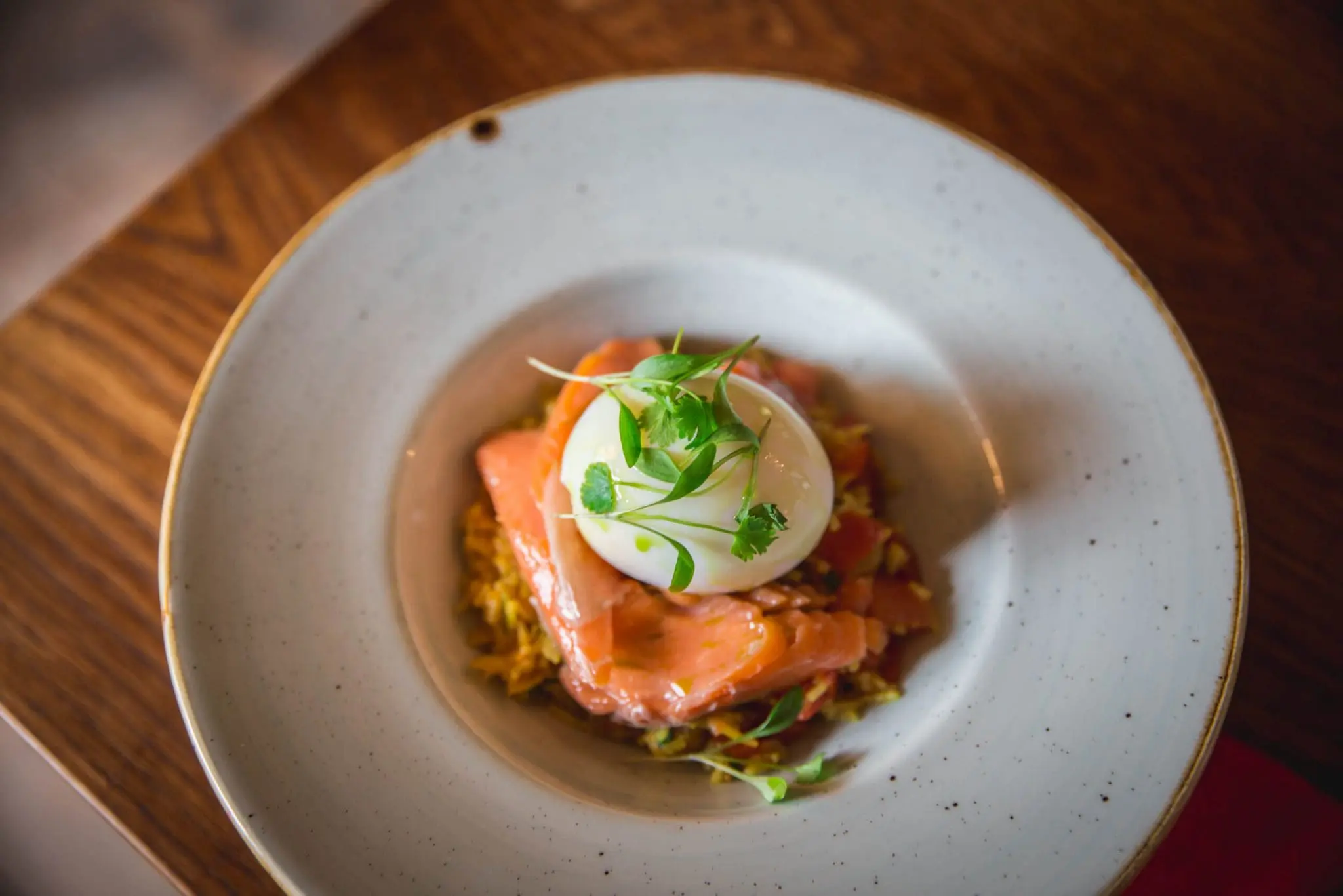 A poached egg on a slice of smoked salmon in a bowl