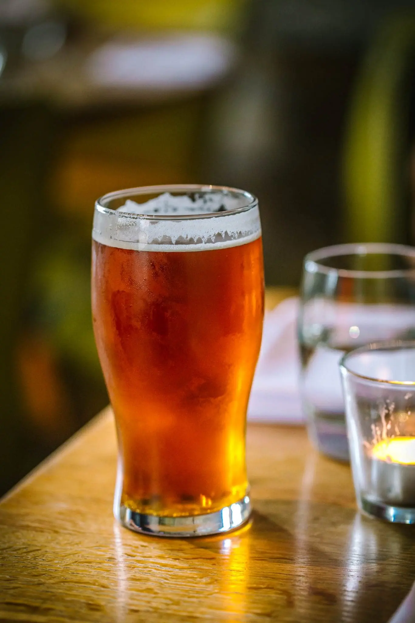 A pint of medium brown beer on a table