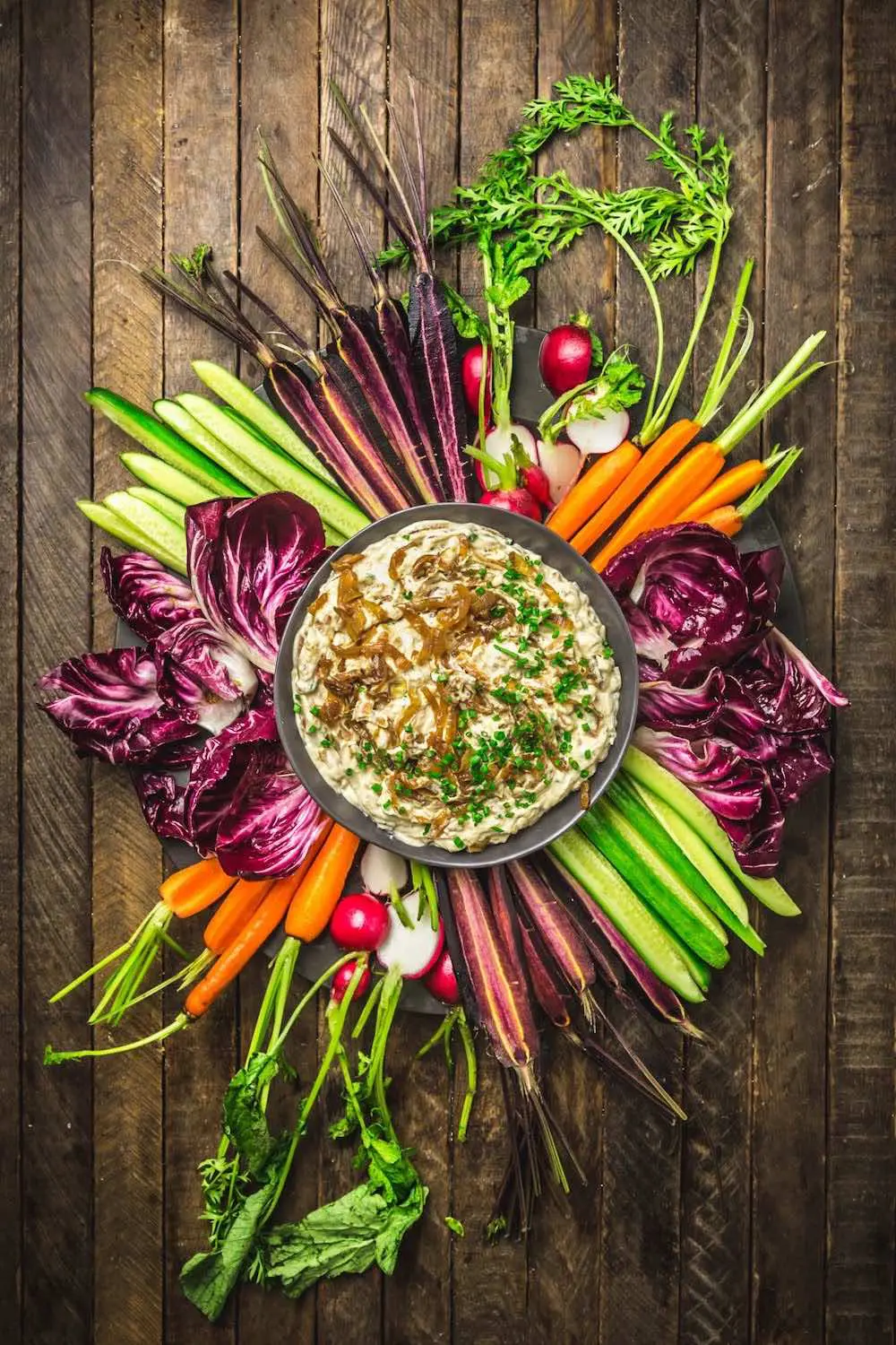 Onion dip surrounded by colorful cut veggies
