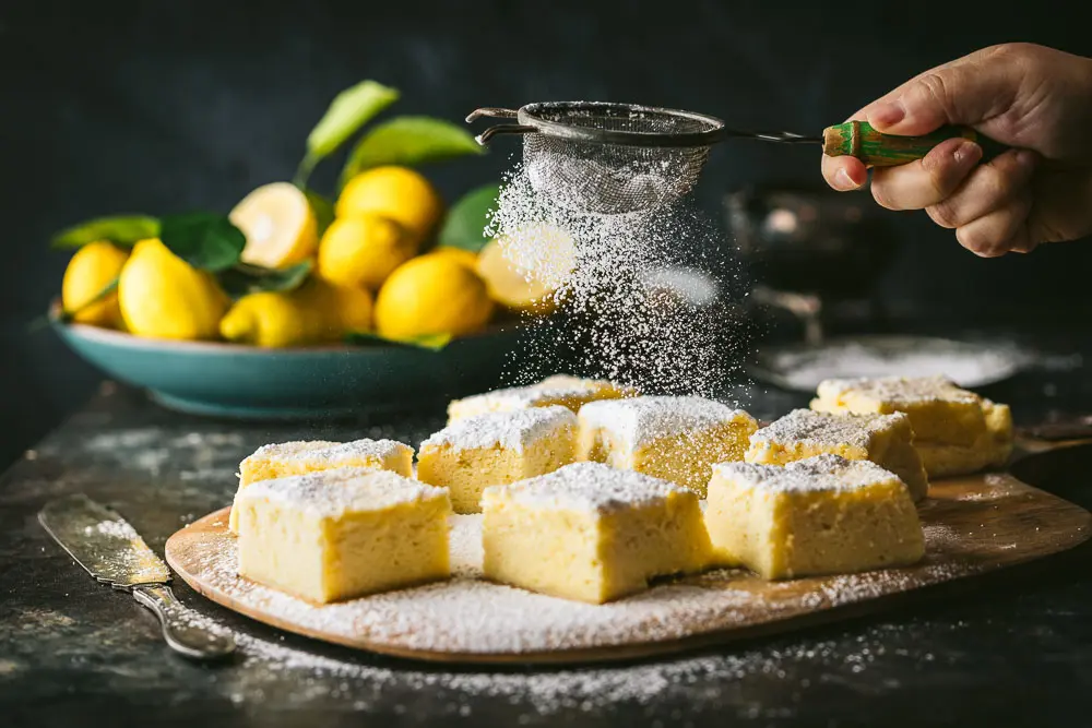 Magic Lemon Cake being sprinkled with powdered sugar
