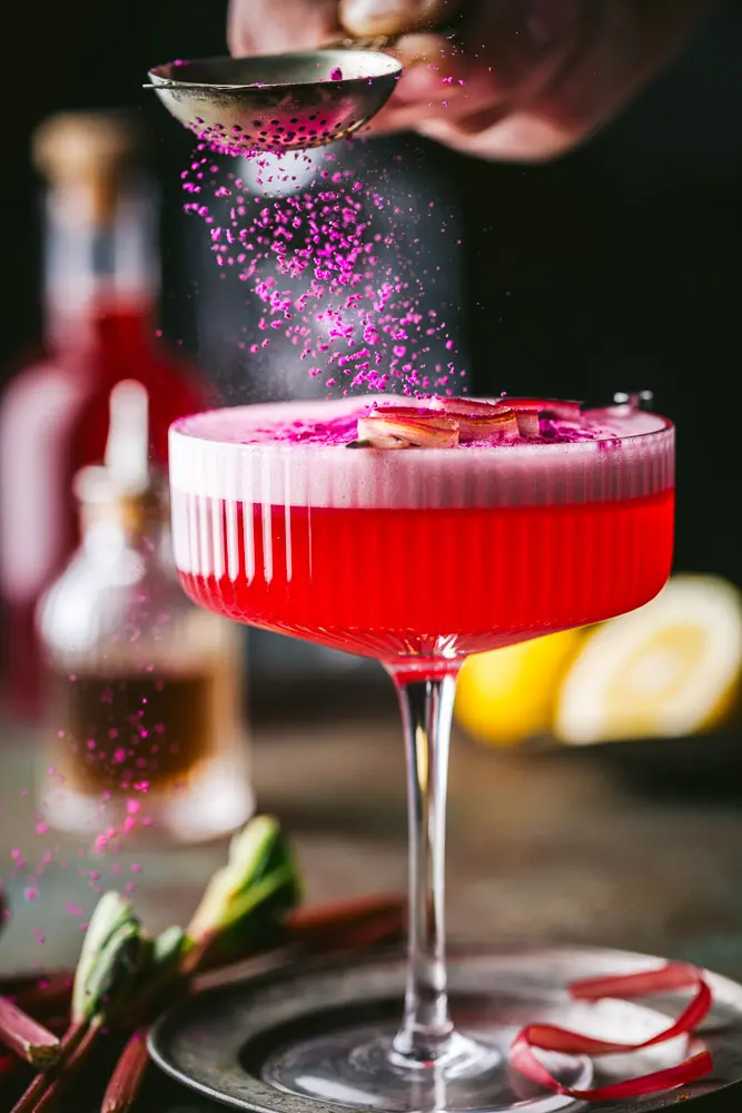 Action shot of sprinkling garnish on Rhubarb Cocktail 1