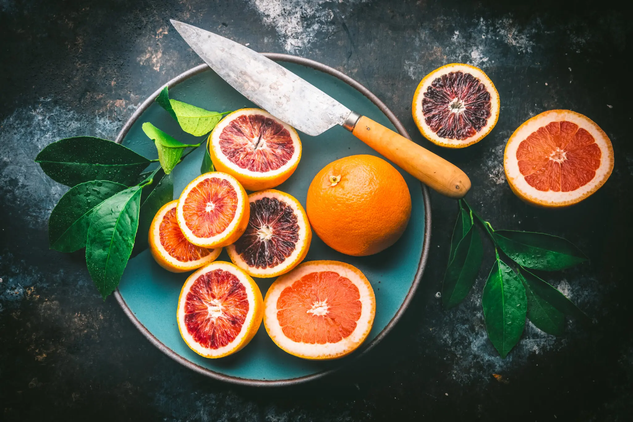 Blood Oranges, pink grapefruit and knife in Blue Bowl and table