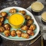 Plate of pigs in blankets with a cheesy dip