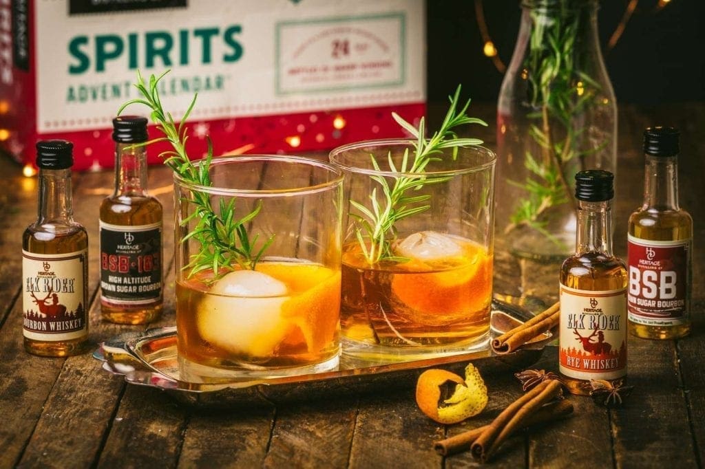Two old-fashioned cocktails with miniature spirit bottles