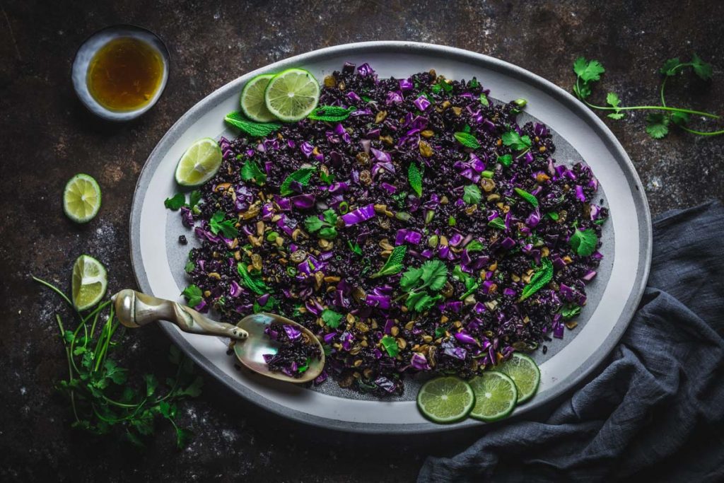 A platter of black rice sprinkled with herbs