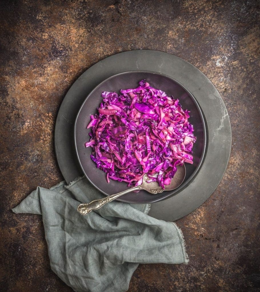 A pewter plate with braised red cabbage and a napkin