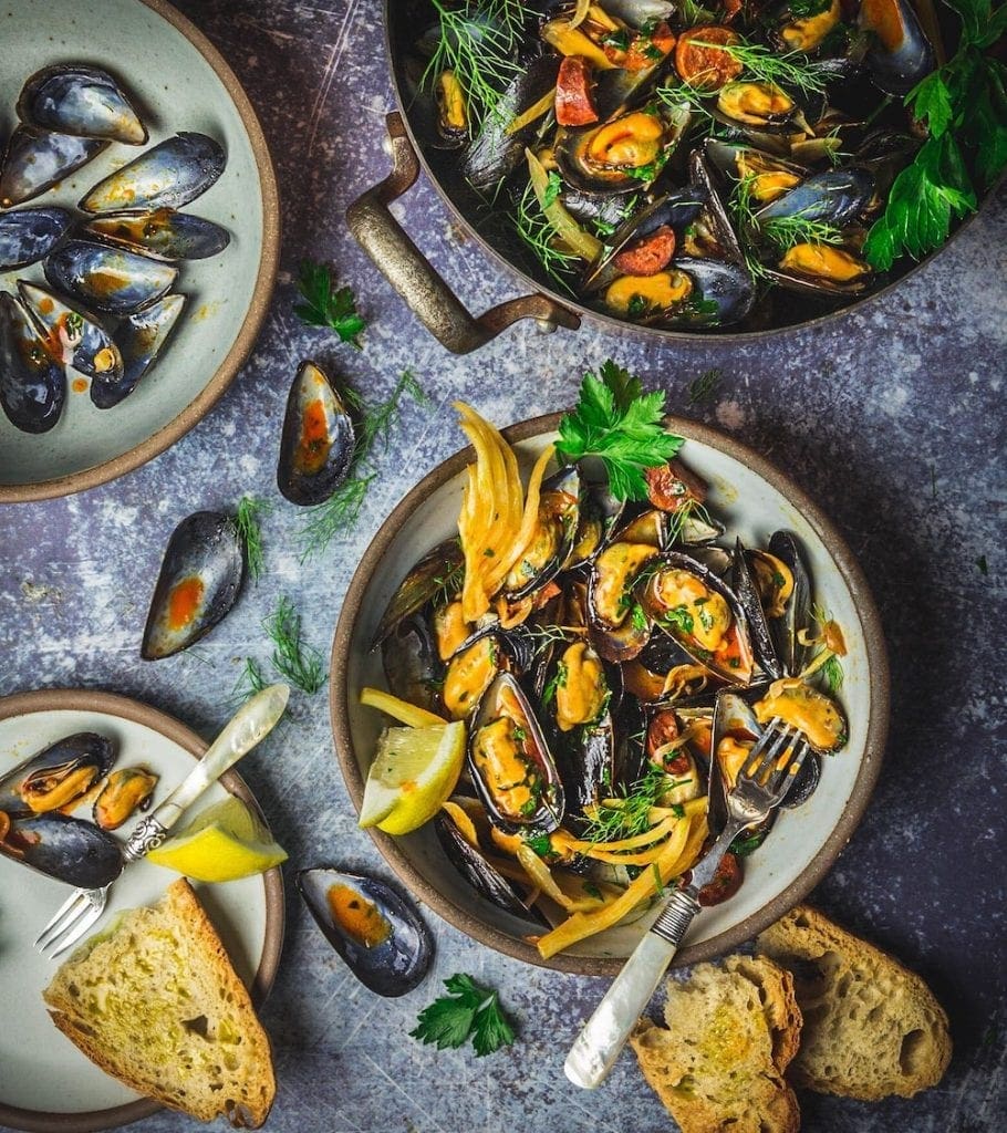 Bowls of cooked mussels with fennel and chorizo
