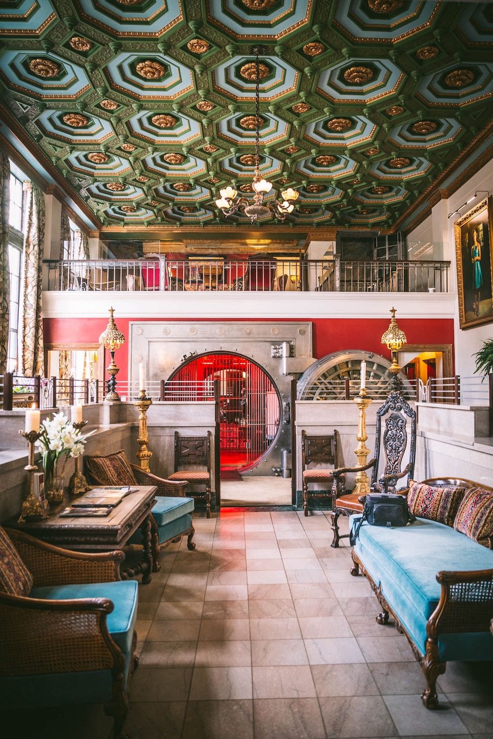 The grand interior of a hotel with ornate furniture and a converted bank vault