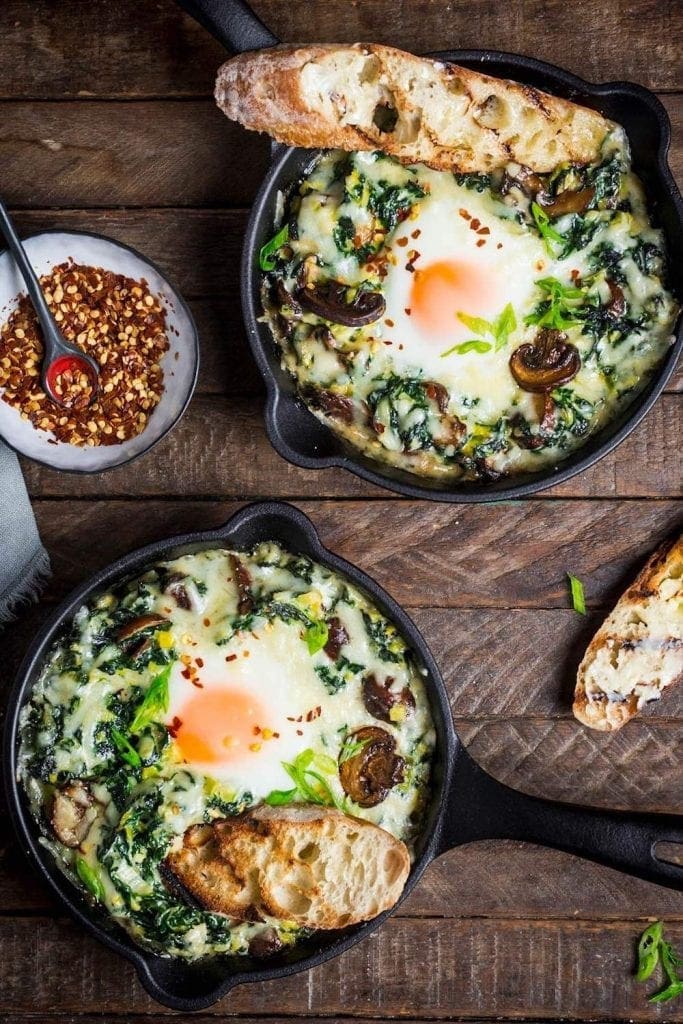 Baked eggs over greens in little cast iron skillets