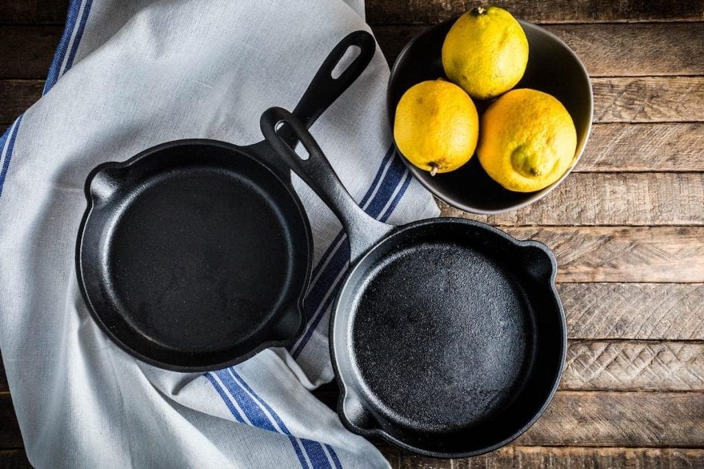 Two small cast iron skillets with a bowl of lemons