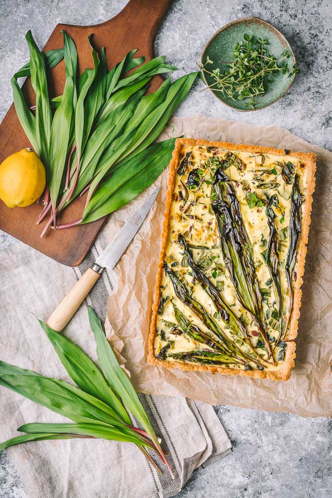 Ramp Tart on parchment with fresh ramps  bunched beside it