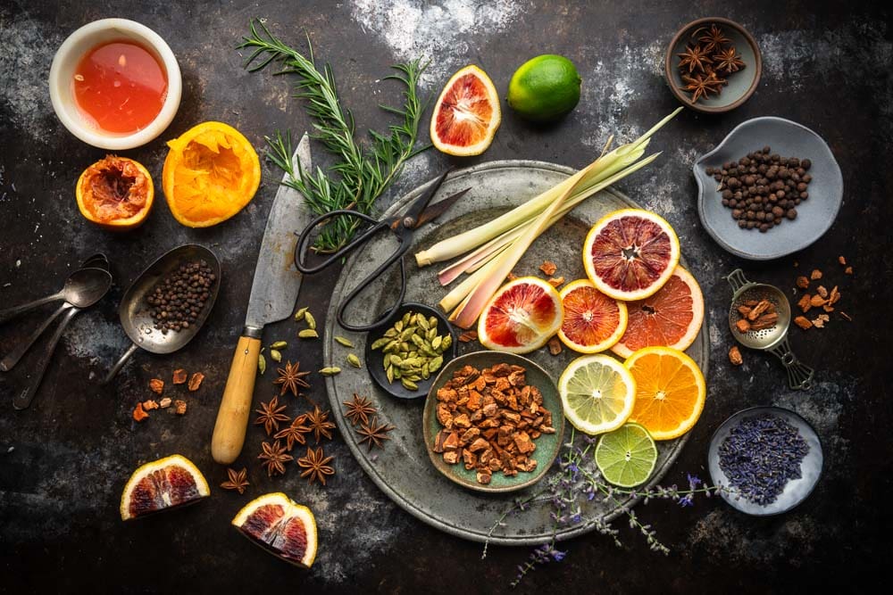 Citrus slices, juice, herbs and spices - most of the ingredients for homemade tonic