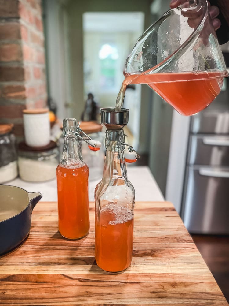 Pouring homemade tonic into bottles