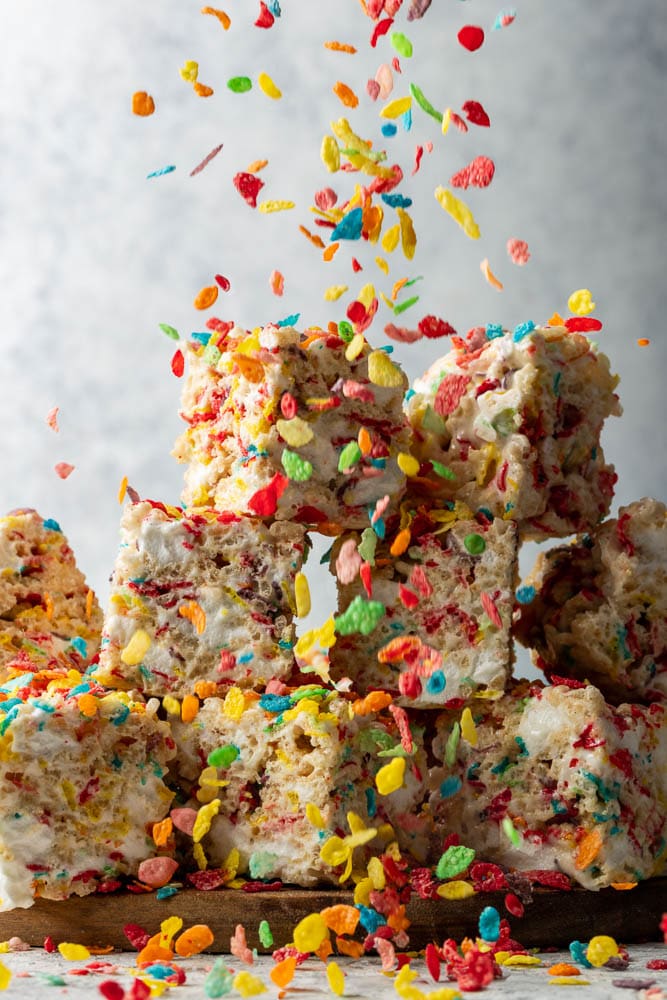 Fruity pebbles raining down on a stack of Rice Krispie Treats
